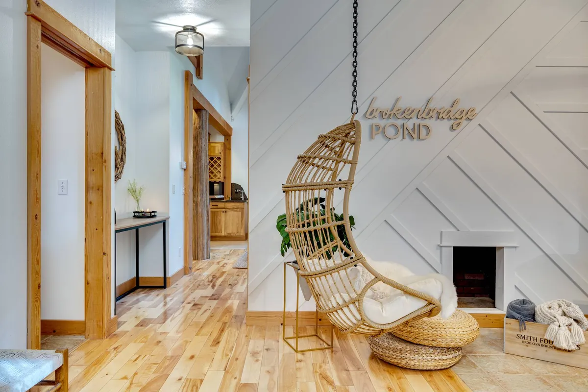 A cozy nook featuring a hanging egg chair, rich wooden accents, and a decorative sign. The inviting space is perfect for reading, relaxing, or finding creative inspiration, making it ideal for both downtime and remote work.